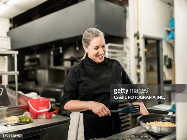 portrait of female chef at the commercial kitchen - catering black uniform stockfoto's en -beelden