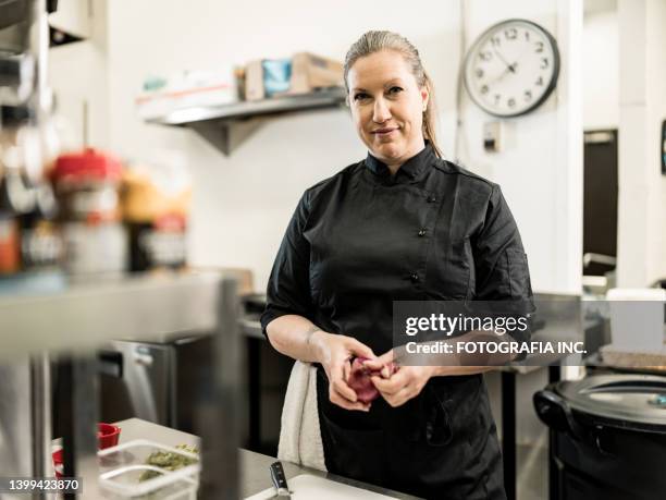 portrait of female chef at the commercial kitchen - kokkin stockfoto's en -beelden