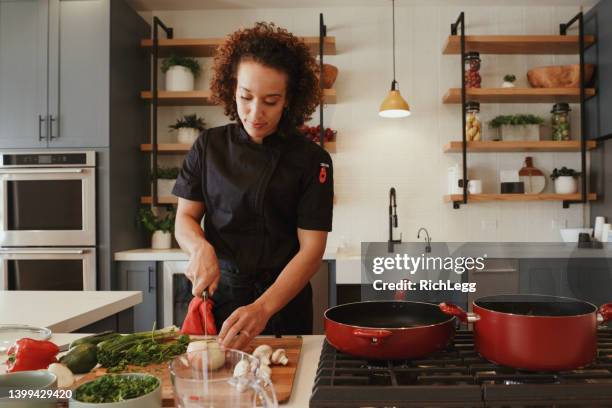 professional chef at work in a kitchen - chef coat stock pictures, royalty-free photos & images