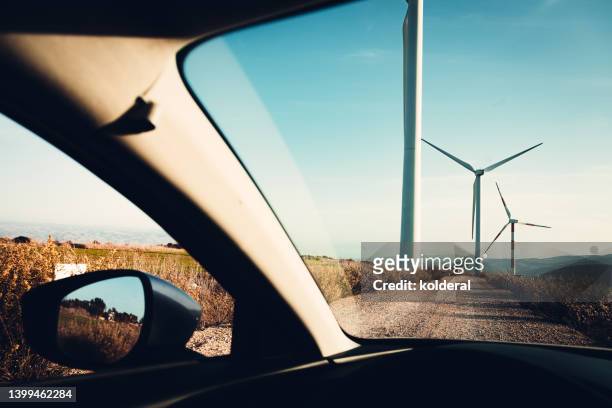 driving on country road towards wind turbines - car point of view stock pictures, royalty-free photos & images