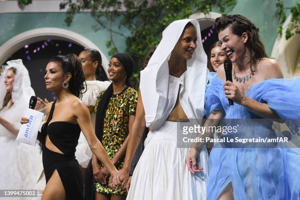 Eva Longoria, Noémie Lenoir and Milla Jovivich on stage after the fashion show during the fashion show during the amfAR Cannes Gala 2022 at Hotel du...