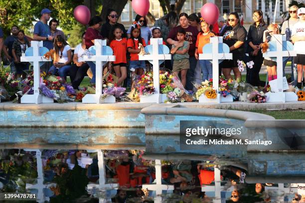 People visit memorials for victims of Tuesday's mass shooting at a Texas elementary school, in City of Uvalde Town Square on May 26, 2022 in Uvalde,...