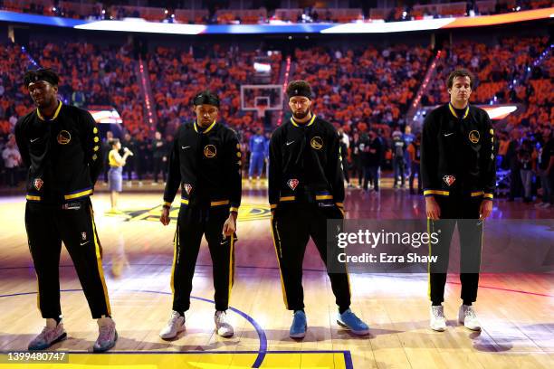 Kevon Looney, Moses Moody, Klay Thompson and Nemanja Bjelica of the Golden State Warriors stand for a moment of silence for the victims of the mass...