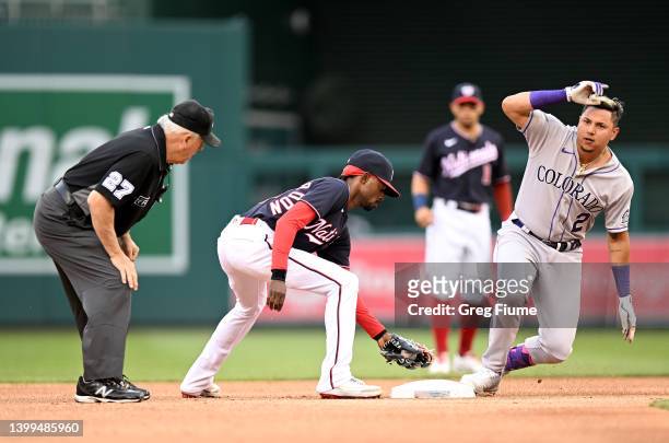 Yonathan Daza of the Colorado Rockies slides into second base for a double in the first inning ahead of the tag of Dee Strange-Gordon of the...