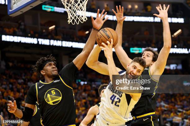 Maxi Kleber of the Dallas Mavericks drives to the basket against Kevon Looney and Nemanja Bjelica of the Golden State Warriors during the second...