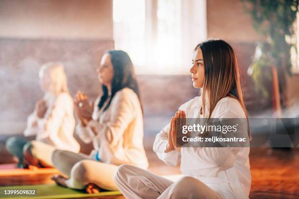 group of people meditating visualising during yoga session - kundalini imagens e fotografias de stock