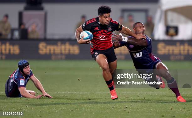 Leicester Fainga'anuku from the Crusaders breaks the tackles of Hamish Stewart, left, and 14. Suliasi Vunivalu from the Reds during the round 15...