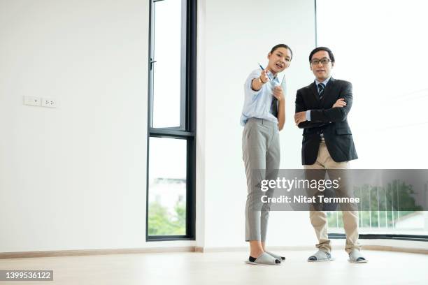 focus on the customer's unique needs in real estate industry. an asian female real estate agent showing energy efficient solutions for a new home to a japanese businessman in a model house. - customer needs stock pictures, royalty-free photos & images