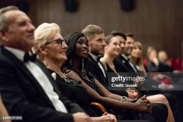 espectadores sonrientes sentados en el teatro - opera lirica fotografías e imágenes de stock