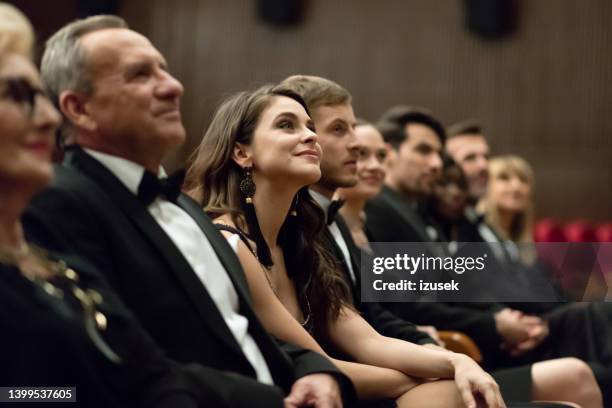 lächelnde zuschauer sitzen im theater - arts for humanity gala stock-fotos und bilder