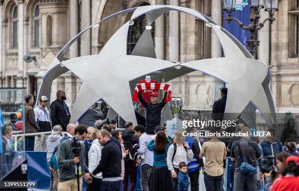 Fans pose with the UEFA Champions League trophy at Hotel de Ville on day 2 of the UEFA Champions League Final 2021/22 Festival ahead of the UEFA...