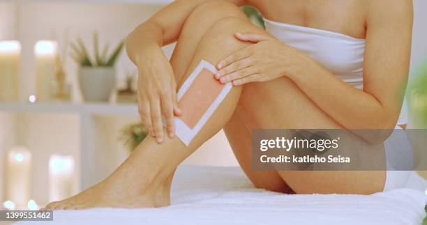 mujer depilándose las piernas en un spa. primer plano de una mujer disfrutando de un relajante día de belleza y bienestar en un spa de salud de lujo y recibiendo un tratamiento de belleza - waxing hair removal fotografías e imágenes de stock