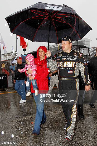 Ryan Newman, driver of the U.S. Army/Quicken Loans Chevrolet, walks with wife Krissie and daughter Brooklyn back to the garage during a rain delay...