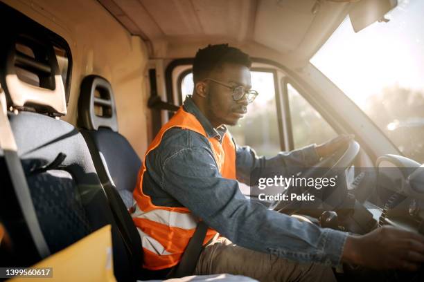 jeune chauffeur-livreur au travail - camionnette photos et images de collection