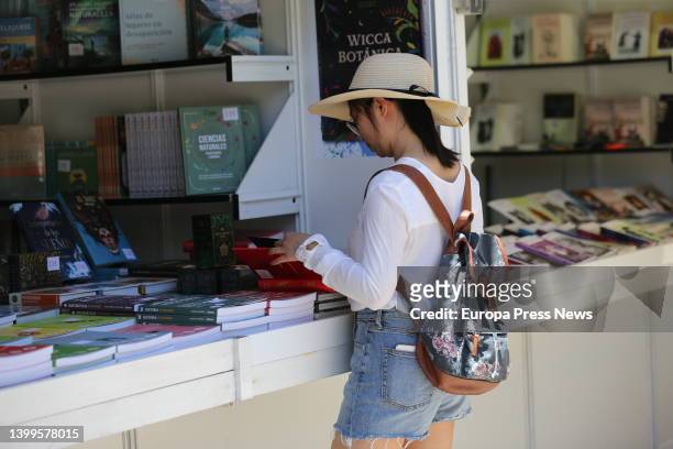 Person leafs through a book during the start of the 2022 Book Fair in El Retiro, on May 27 in Madrid, Spain. The Madrid Book Fair 2022 will be "the...