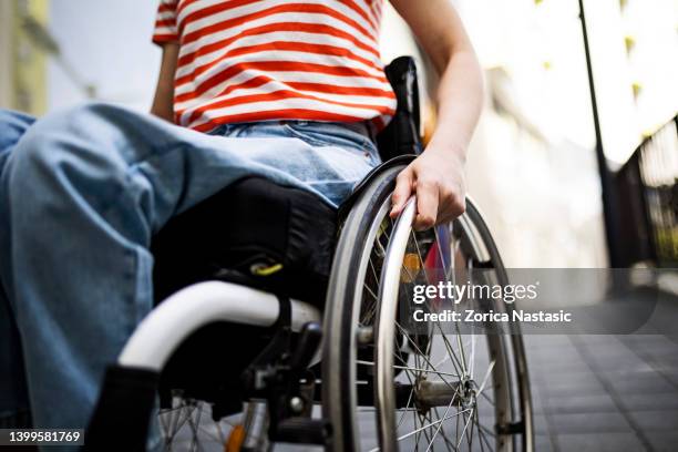 unrecognizable woman in wheelchair holding wheels - rear view hand window stock pictures, royalty-free photos & images