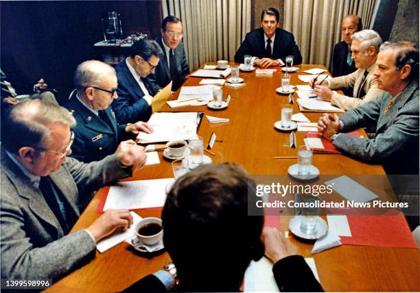 President Ronald Reagan meets with his National Security Advisors in the Situation Room, Washington DC, October 23, 1983. Clockwise from bottom,...