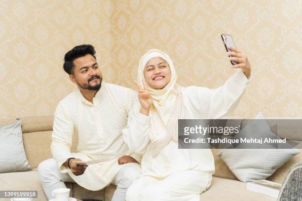 young brother & sister clicking selfie using a mobile phone. - father clicking selfie stock-fotos und bilder