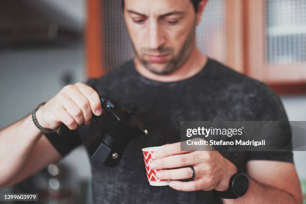 young boy pouring a coffee in the cup - 40's rumpled business man stockfoto's en -beelden