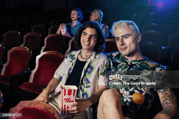 gay couple on date at movie theatre - casual couple photos et images de collection