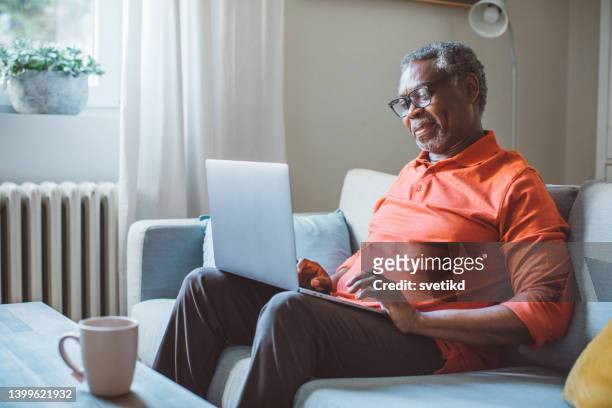 hombre maduro usando una computadora portátil - middle aged computer fotografías e imágenes de stock