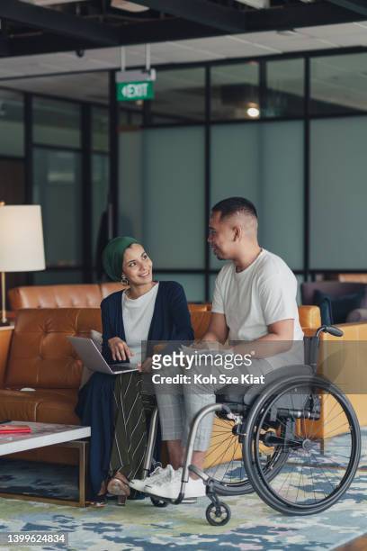teamwork in business - a female leader sharing insights with a disabled co worker - diversity and inclusion stock pictures, royalty-free photos & images