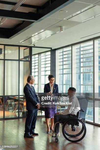 work empwerment - a senior management welcomes a disabled member - obama meets with minister mentor of singapore stockfoto's en -beelden