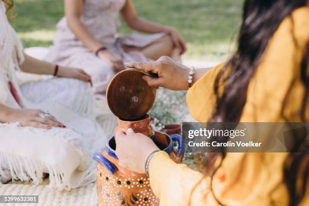 woman pouring cocoa from a clay pot - ceremonie stockfoto's en -beelden