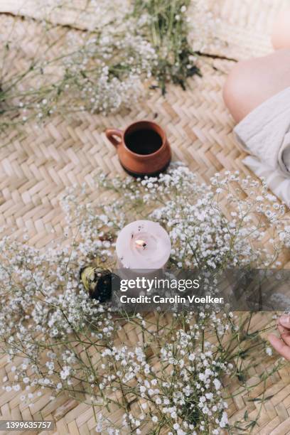 a candle and clay mug on a woven mat - ceremonia fotografías e imágenes de stock