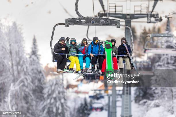 large group of happy skiers and snowboarders on a ski lift. - friends skiing stock pictures, royalty-free photos & images