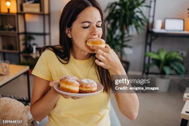 woman with donuts - eating donuts stockfoto's en -beelden