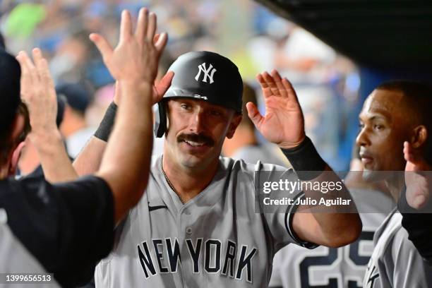 Matt Carpenter of the New York Yankees celebrates with teammates in the dugout after hitting a home run in the fourth inning against the Tampa Bay...