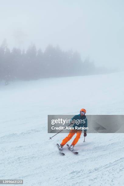 a skier makes a sharp turn while skiing down a ski run in british columbia. - whistler-blackcomb-ski-resort stock pictures, royalty-free photos & images