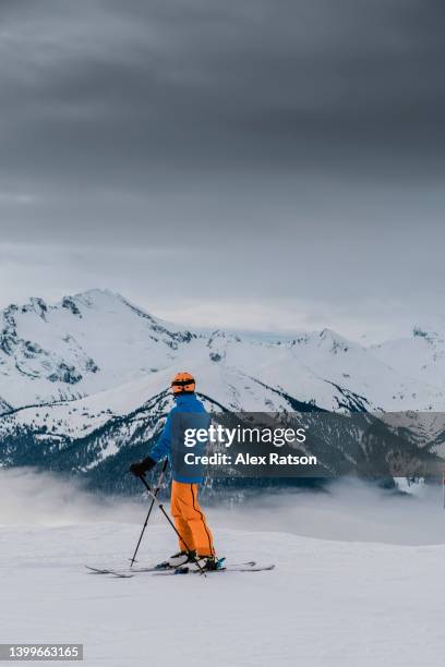 a skier stops and enjoys a scenic view on whistler mountain - alpine skiing stock pictures, royalty-free photos & images