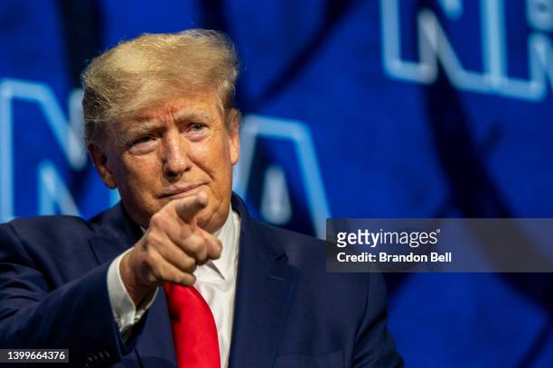 Former U.S. President Donald Trump points to the crowd on arrival at the National Rifle Association annual convention at the George R. Brown...