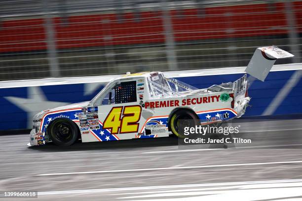 Carson Hocevar, driver of the Premier Security Solutions Chevrolet, drives a damaged truck after an on-track incident during the NASCAR Camping World...