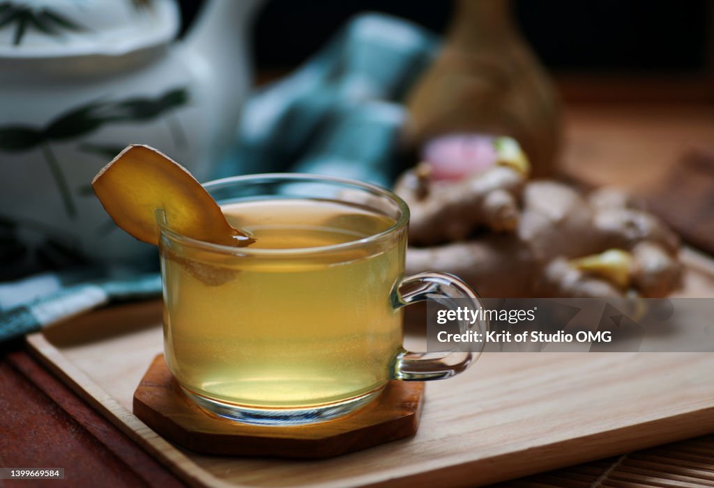 A cup of ginger tea on the wooden tray