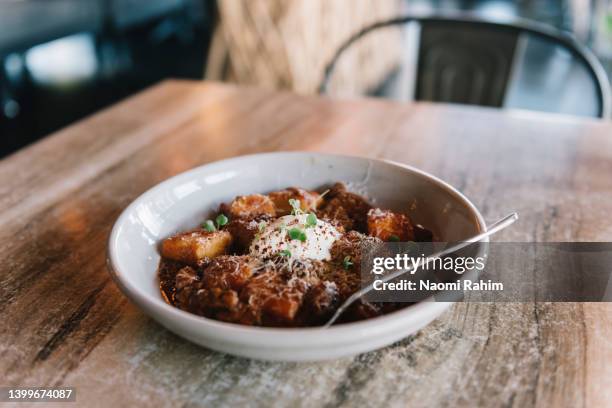 gourmet gnocchi with slow cooked beef ragu dish, served on a timber table - mildura stock pictures, royalty-free photos & images