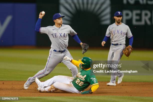 Corey Seager of the Texas Rangers gets the out at second base of Ramon Laureano of the Oakland Athletics and turns a double play to first base in the...