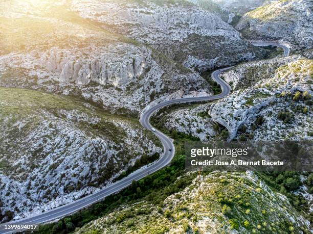 aerial view, road between mountains with many curves. - mountain roads stock-fotos und bilder