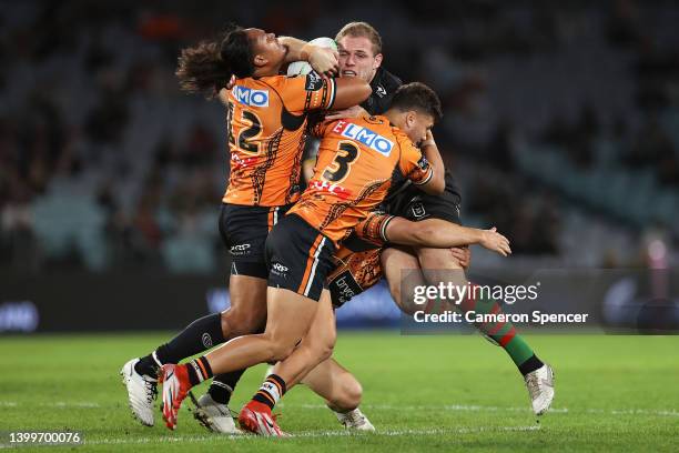 Thomas Burgess of the Rabbitohs is tackled during the round 12 NRL match between the South Sydney Rabbitohs and the Wests Tigers at Accor Stadium, on...