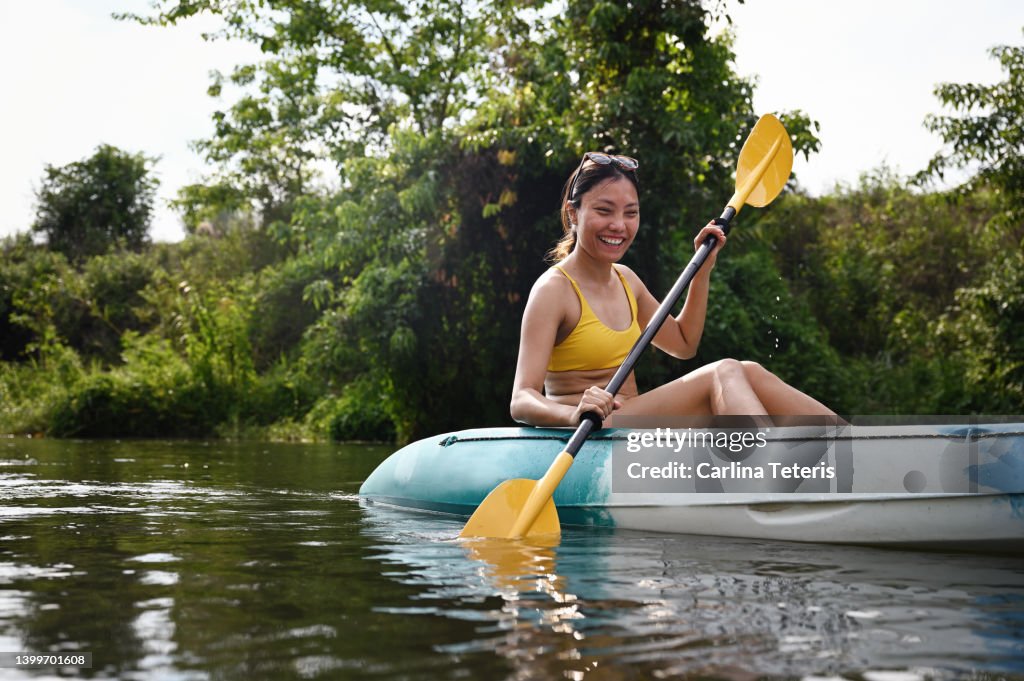 Asian woman kayaking alone