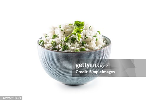 Bowl of rice with peas and parsley leaf on an isolated white background. Bowl of rice with peas and parsley leaf on an isolated white background.