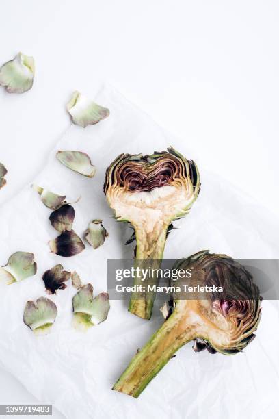 cleaning artichokes before cooking. exotic vegetables. healthy food. farm harvest. dish ingredients. - alcachofra imagens e fotografias de stock