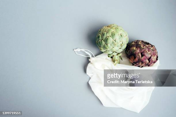 purple and green artichoke in eco bag. ecological lifestyle. fries plastic. exotic vegetables. healthy food. farm harvest. dish ingredients. - french fries white background stock-fotos und bilder
