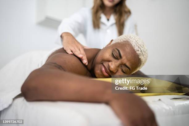 mature woman getting massage at spa - massage table stock pictures, royalty-free photos & images