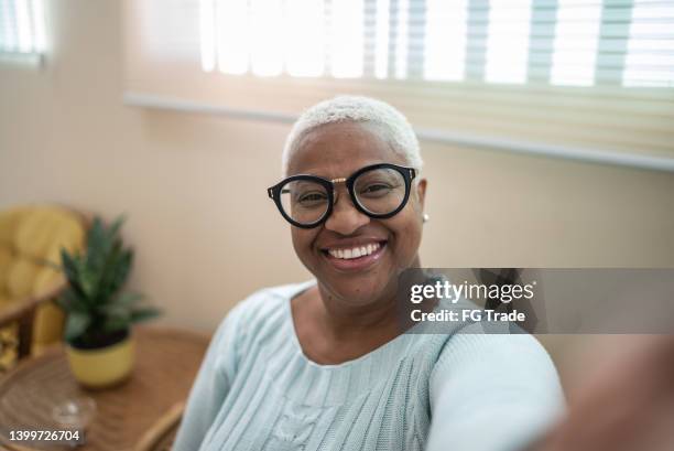 mature woman taking a selfie or filming at home - camera point of view - selfie indoors stock pictures, royalty-free photos & images