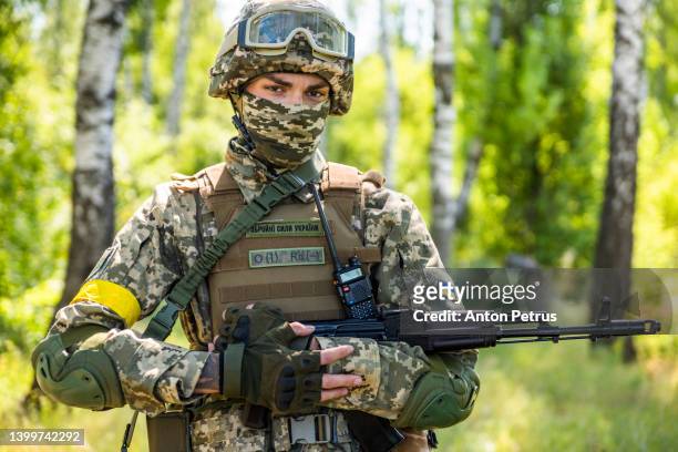 ukrainian soldier with a machine gun in the forest - soldado do exercito imagens e fotografias de stock