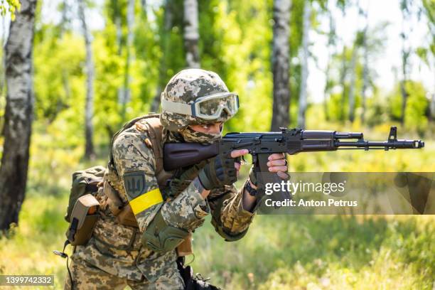 ukrainian soldier with a machine gun in the forest - army helmet stock pictures, royalty-free photos & images