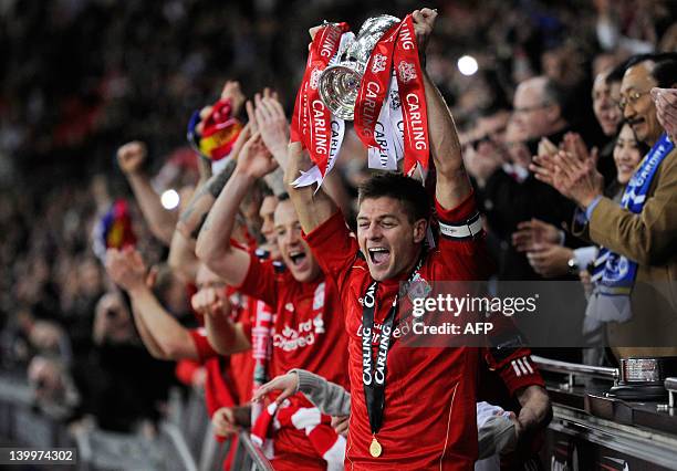 Liverpool's English footballer Steven Gerrard lifts the trophy after beating Cardiff City in a penalty shoot out in the League Cup Final at Wembley...